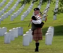 bagpiper standing in grave yard